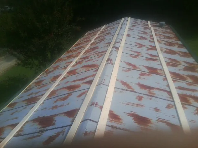 Rusted metal roof panels with new wood purlins before replacement — Storm Damage Roof Repair in Byars by Roofing Brothers