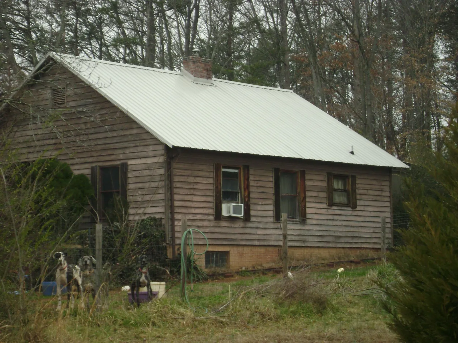 White metal roof on an old wood sided farmhouse, from a Metal Roof Installation job in Byars